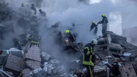 Emergency service workers search a smouldering building