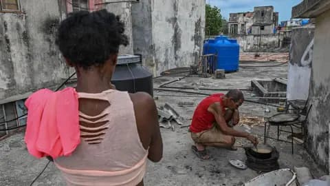 A man cooks with firewood during a blackout in Havana on May 13, 2026. 